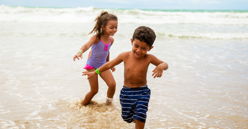 crianças em praia com pulseiras de identificação no verão